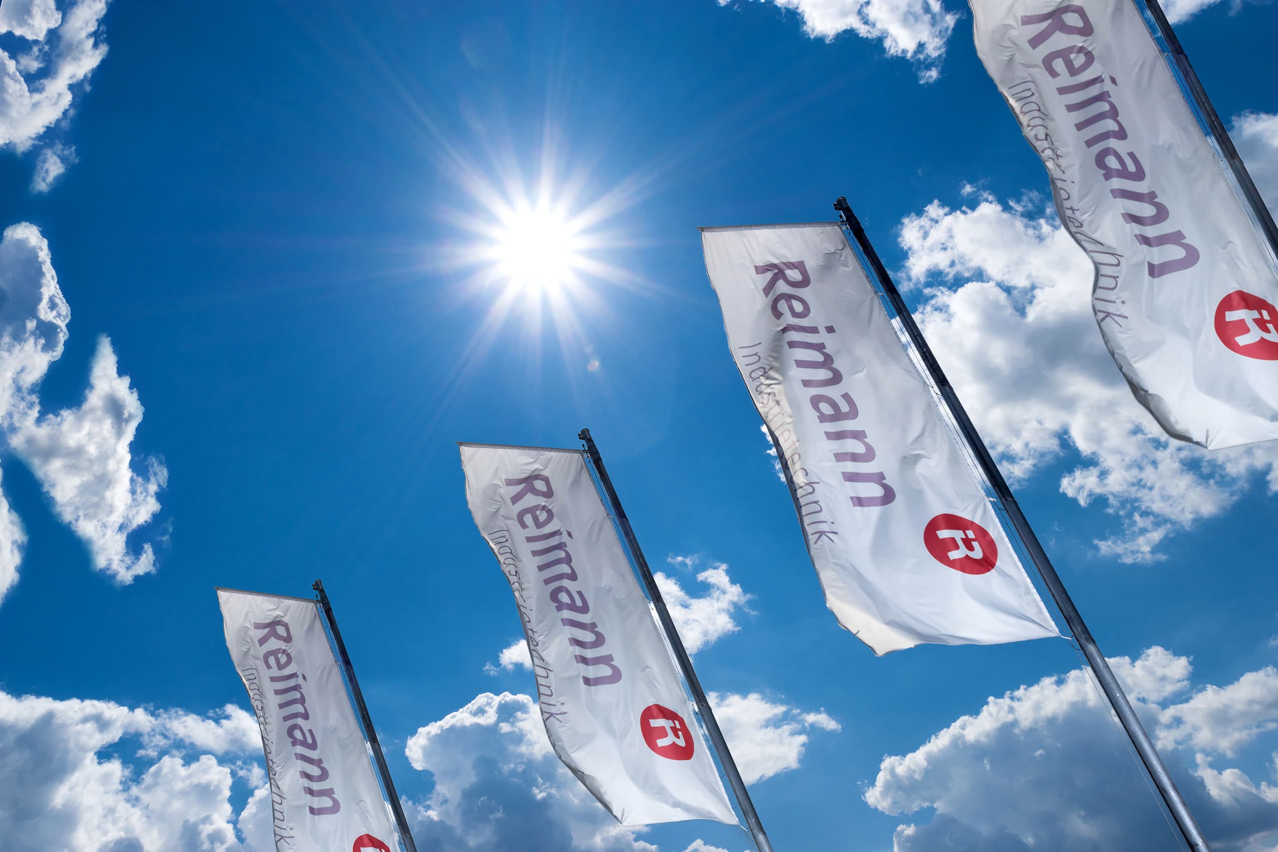 Fahnen der Reimann Industrietechnik GmbH vor blauem Himmel